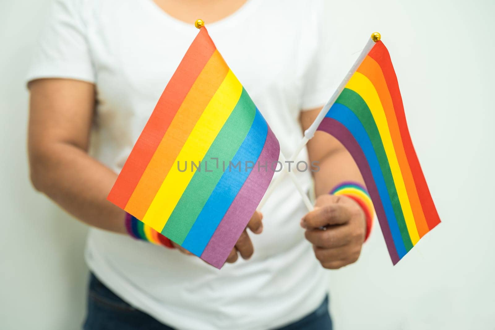 Woman holding LGBT rainbow colorful flag, symbol of lesbian, gay, bisexual, transgender, human rights, tolerance and peace.