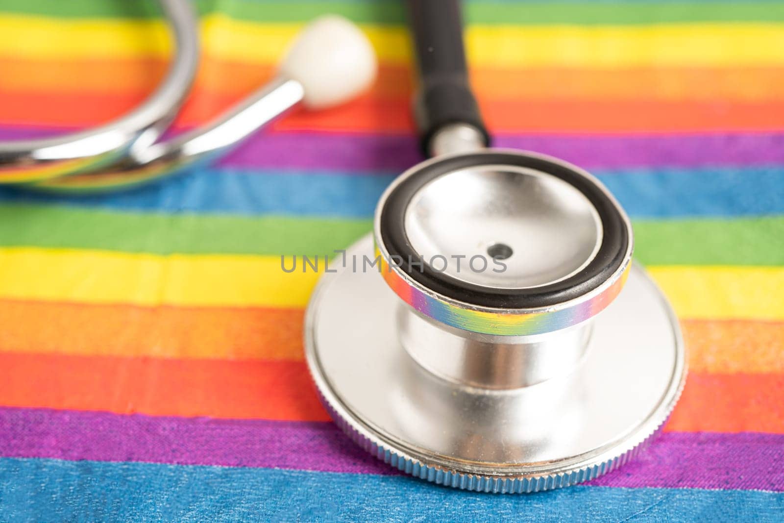 Black stethoscope on rainbow flag, symbol of LGBT pride month celebrate annual in June social, symbol of gay, lesbian, bisexual, transgender, human rights and peace.