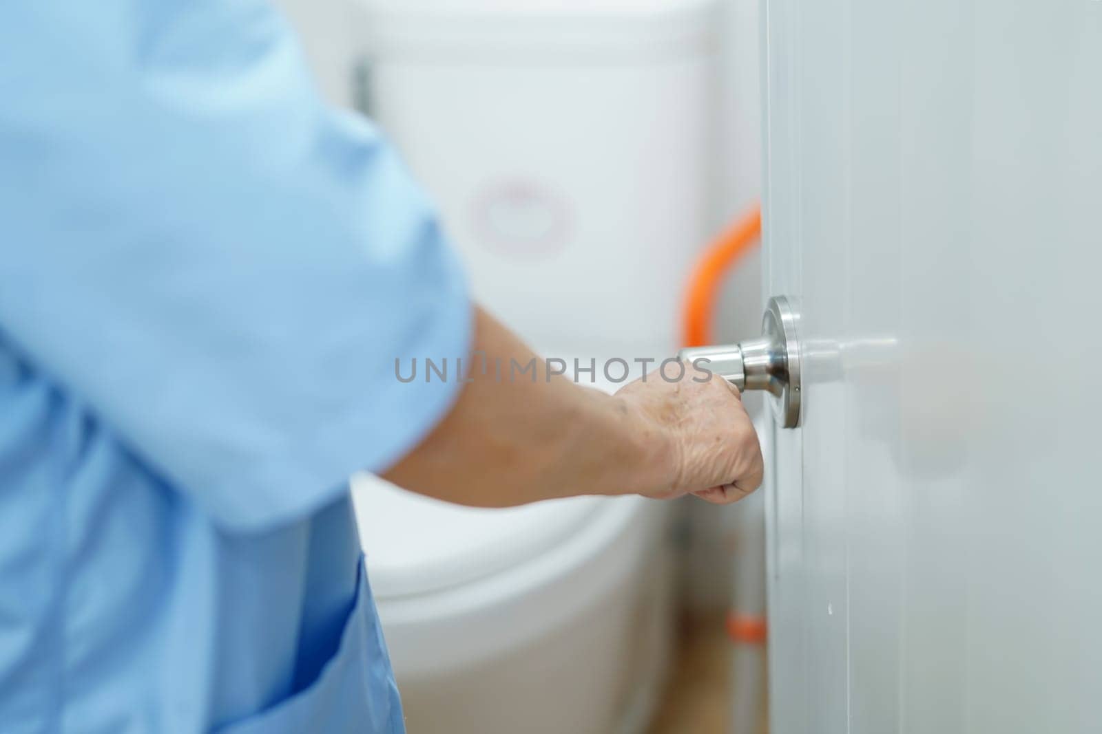 Asian senior woman patient open toilet bathroom by hand in nursing hospital, healthy strong medical. 
   by pamai
