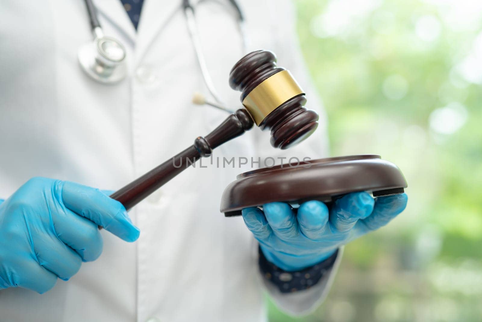 Doctor holding judge gavel, forensic medicine, medical law and crime justice concept. by pamai