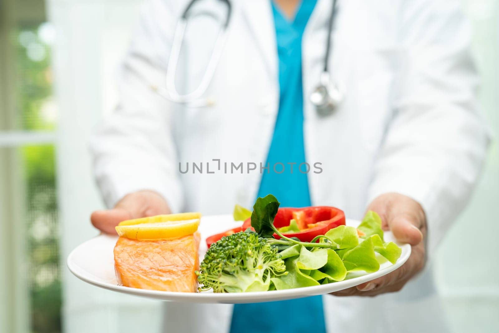 Nutritionist doctor holding healthy salmon steak and vegetable vitamin food for patient in hospital. by pamai