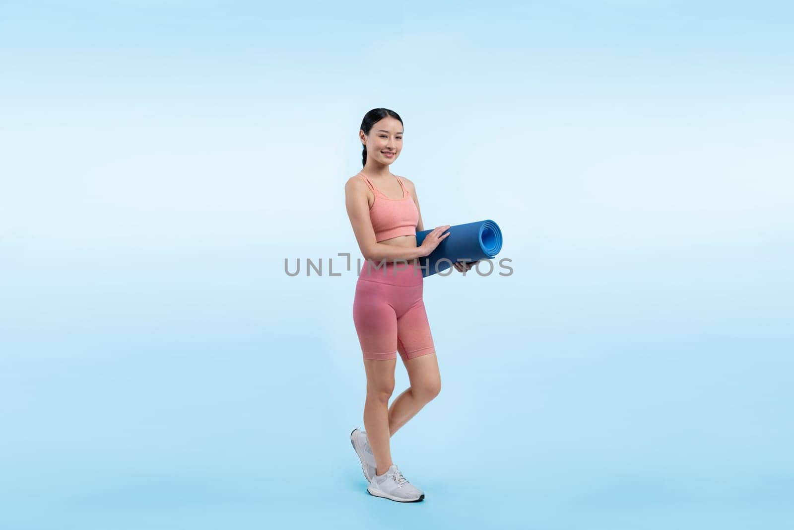 Young attractive asian woman portrait in sportswear with exercising mat. Healthy exercise and workout routine lifestyle concept. Studio shot isolated background. Vigorous