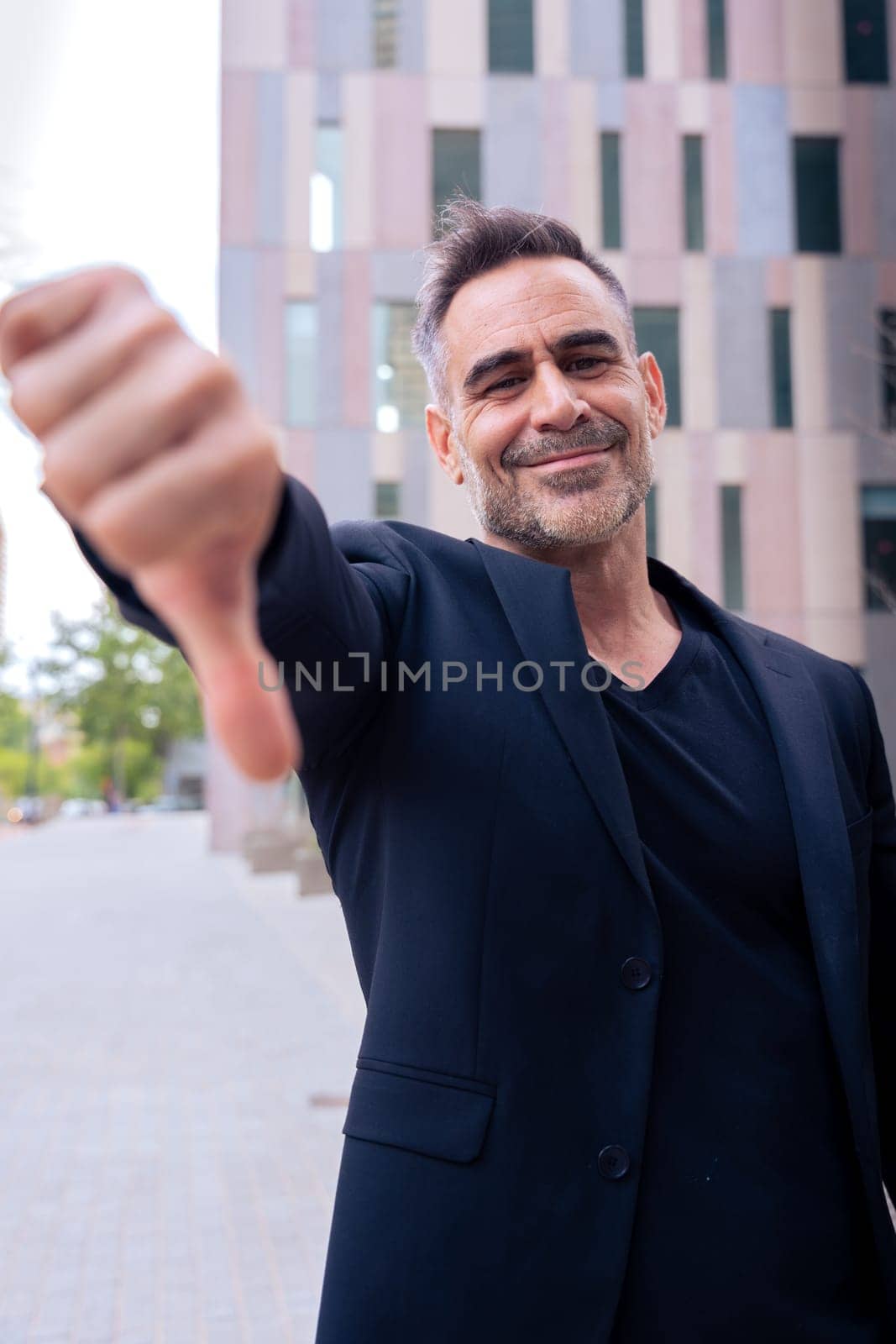 Middle adult man, Caucasian woman, pointing with thumbs down. Angry facial expression.Vertical