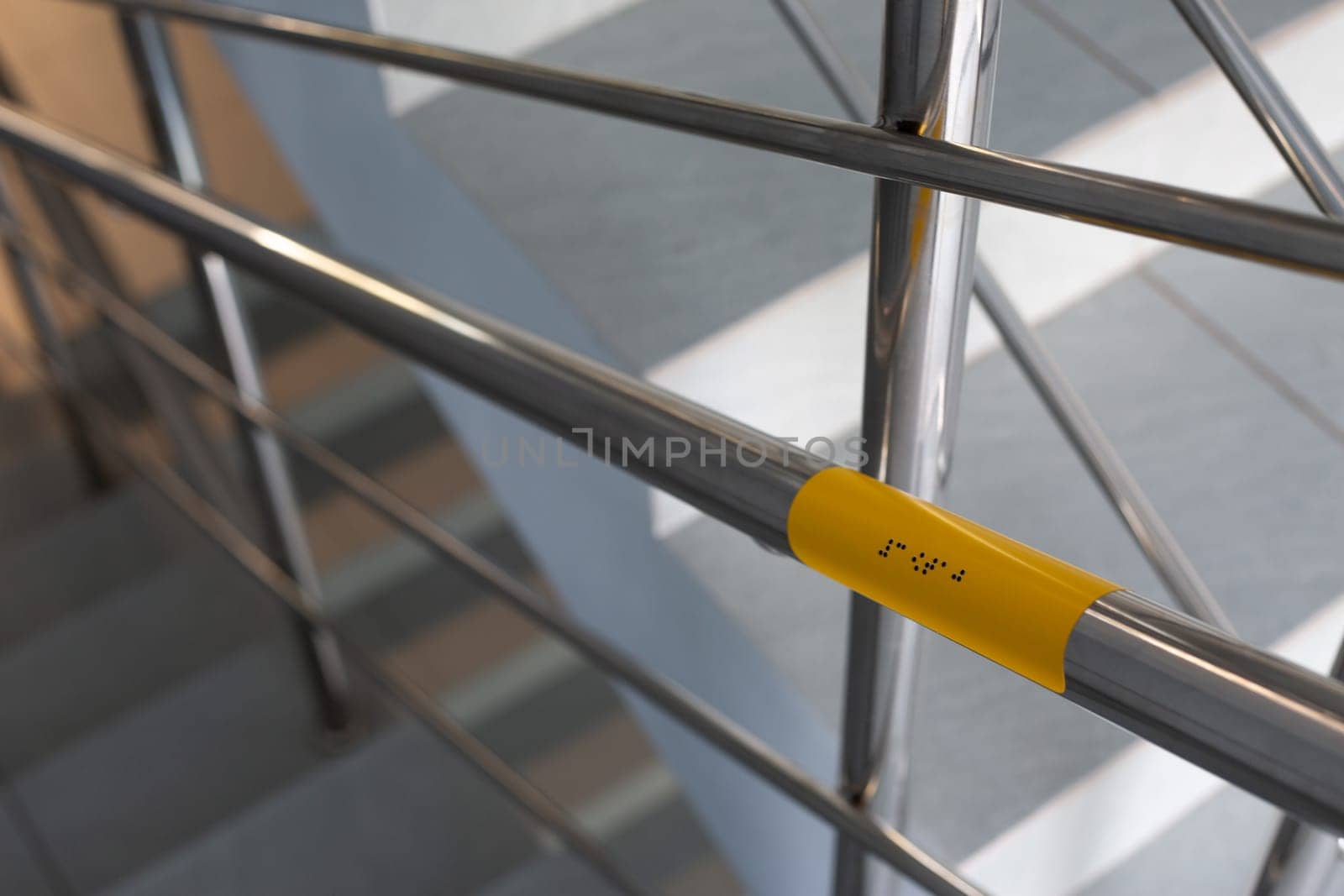 Support blind people on stairs with braille text for help on way. Accessible area for people with disabilities. Modern handicapped care sign with braille text on railings