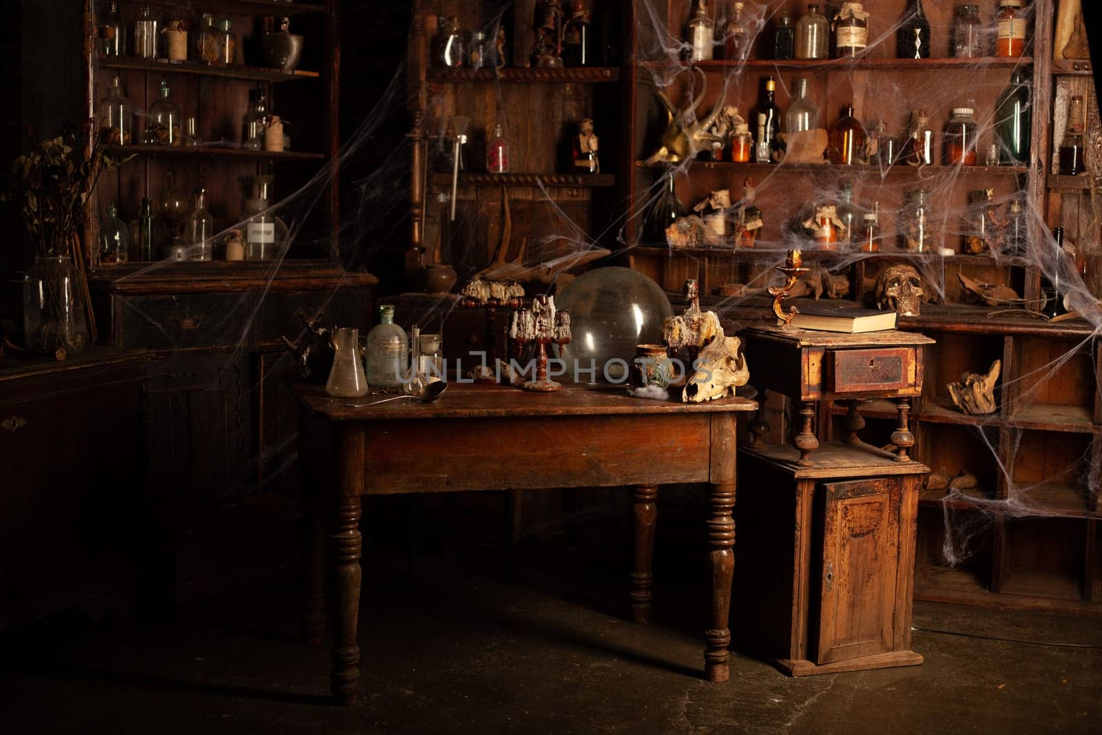 Halloween background Shelves with alchemy tools Skull spiderweb bottle with poison candles Witcher workspace Scarry room