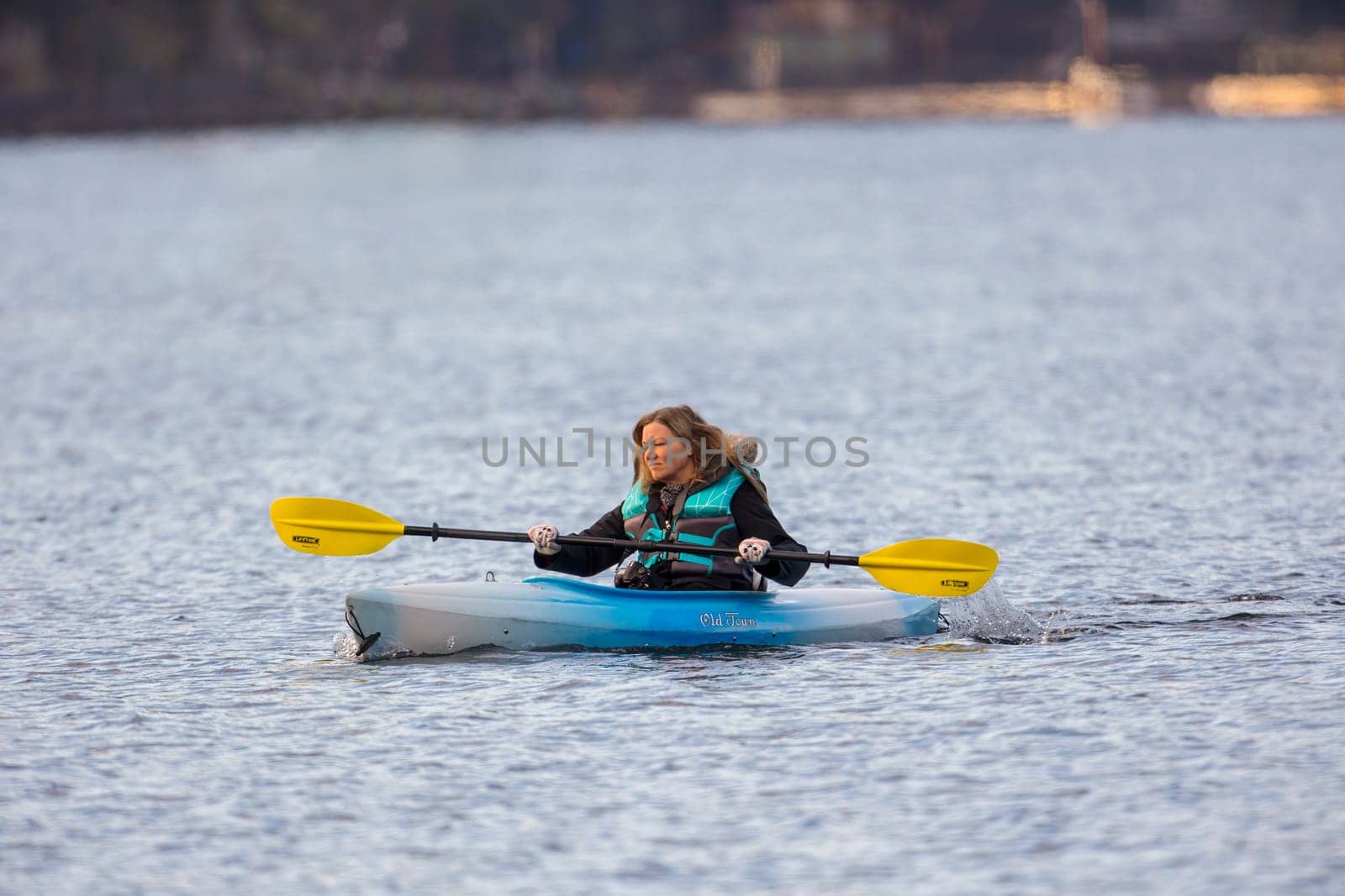 A woman kayaker enjoys a nice but chilly day paddling on Coeur d'Alene, lake in north Idaho.