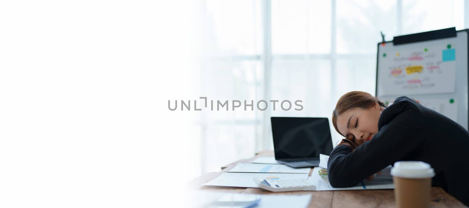 businesswoman plans a finance audit, reviewing documents while battling burnout syndrome