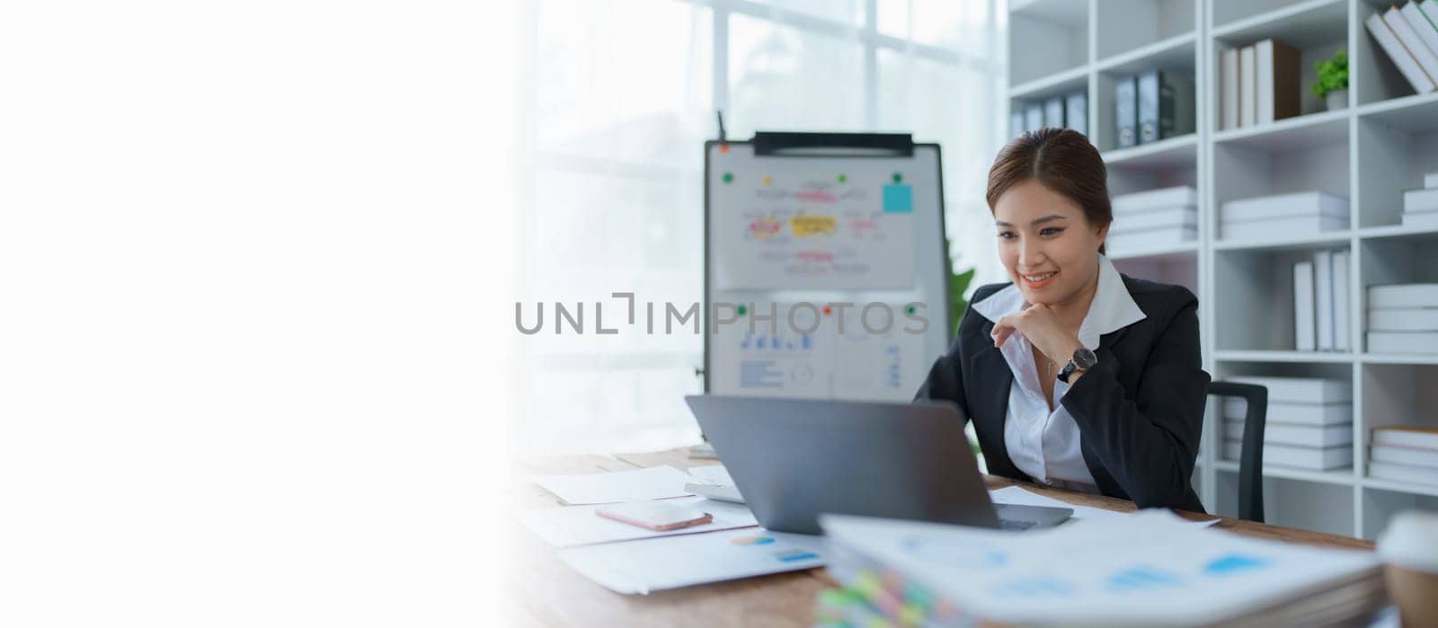 woman plans a finance and budget audit by reviewing organizing office financial documents.