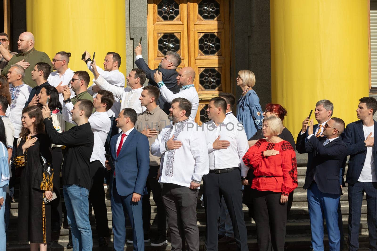KYIV, UKRAINE - Aug. 23, 2024: A solemn ceremony near the Verkhovna Rada on State Flag Day. A group of people's deputies during the flag-raising ceremony and singing of the national anthem
