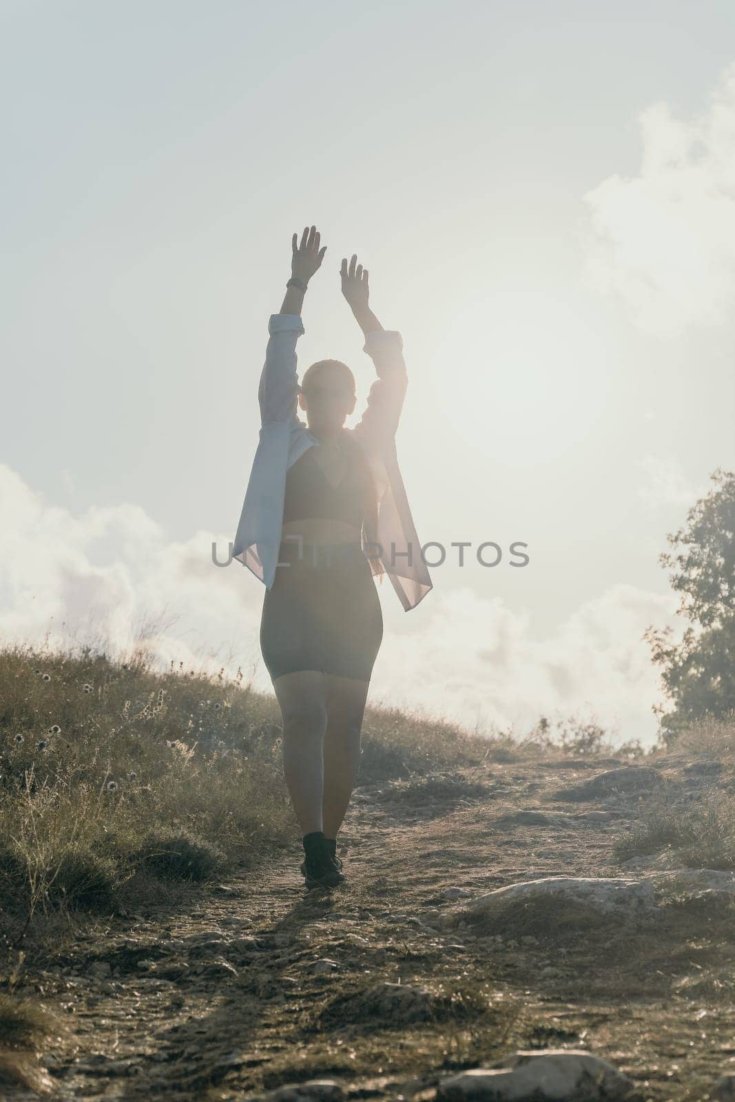 Woman travel sea. Young Happy woman in a long red dress posing on a beach near the sea on background of volcanic rocks, like in Iceland, sharing travel adventure journey