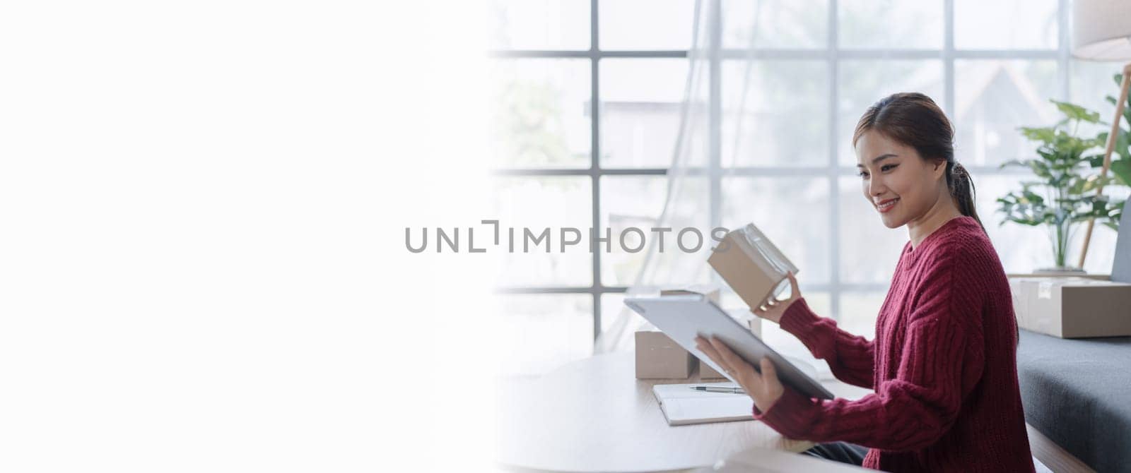 woman, online seller, using a tablet computer efficiently manages customer orders and delivery through the e-commerce platform.