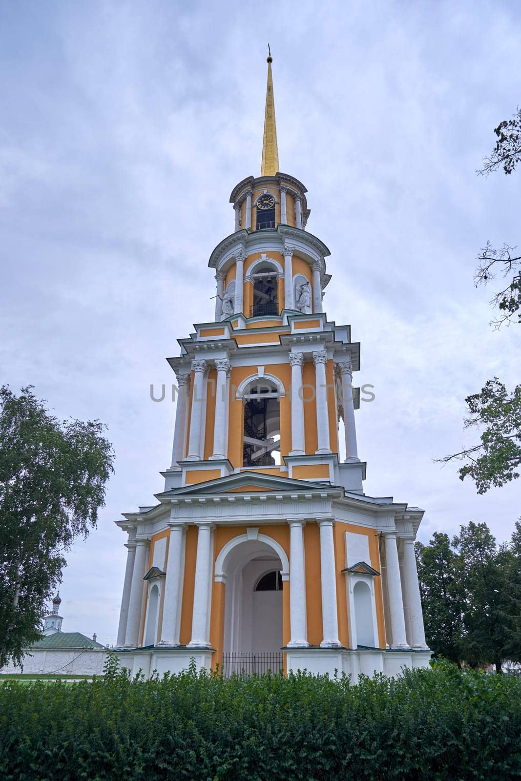 A tall old Russian bell tower against the sky in summer