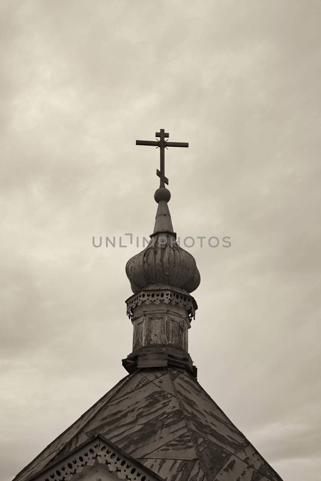 Orthodox cross on top of church. Monochrome image with sepia effect