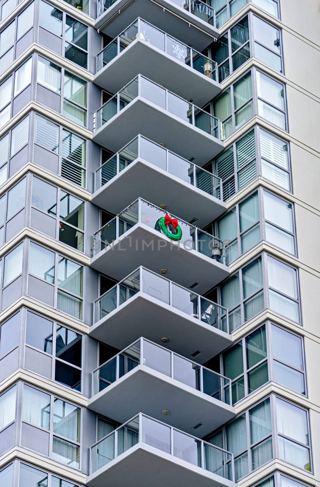 Corner of a residential high-rise building with balconies decorated for Christmas celebration