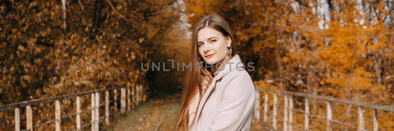 beautiful long-haired woman walks through the autumn streets. Railway, autumn, woman in a coat. by Annu1tochka