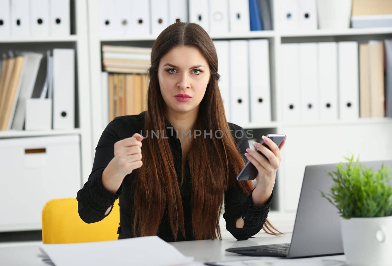 Beautiful brunette smiling businesswoman hold in arm cellphone in office workplace portrait. Stay in touch negotiate meeting job white collar busy life style electronic device store training concept