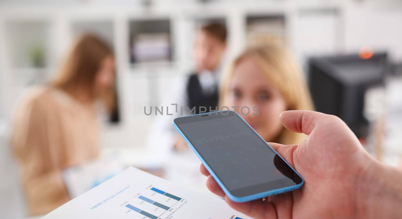 Male hand holding smartphone calculator at office worker people closeup. Internal Revenue Service inspector sum check irs investigation earnings savings loan and credit concept