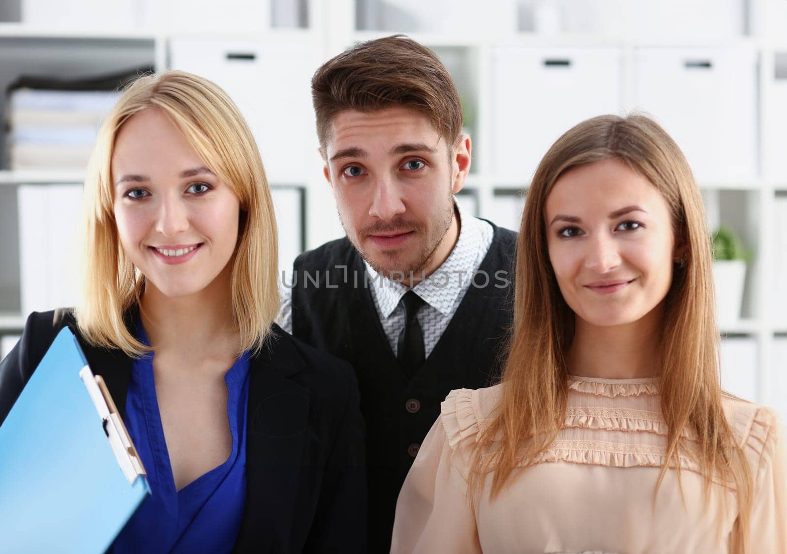 Group of smiling people stand in office looking in camera by kuprevich