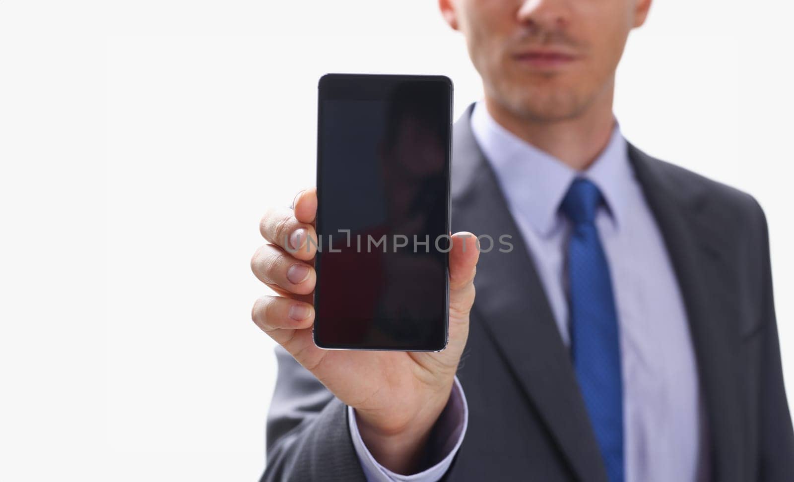 A businessman holding smartphone in hand demonstrates display on which calculator is depicted with figure of zero. The accountant has calculated all transactions are correct debt has credit approx ok