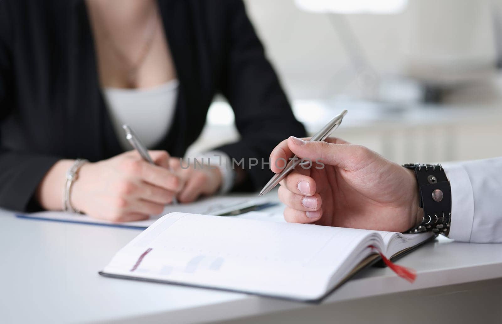 businessmen make notes in notepad. secretary write down words of her boss