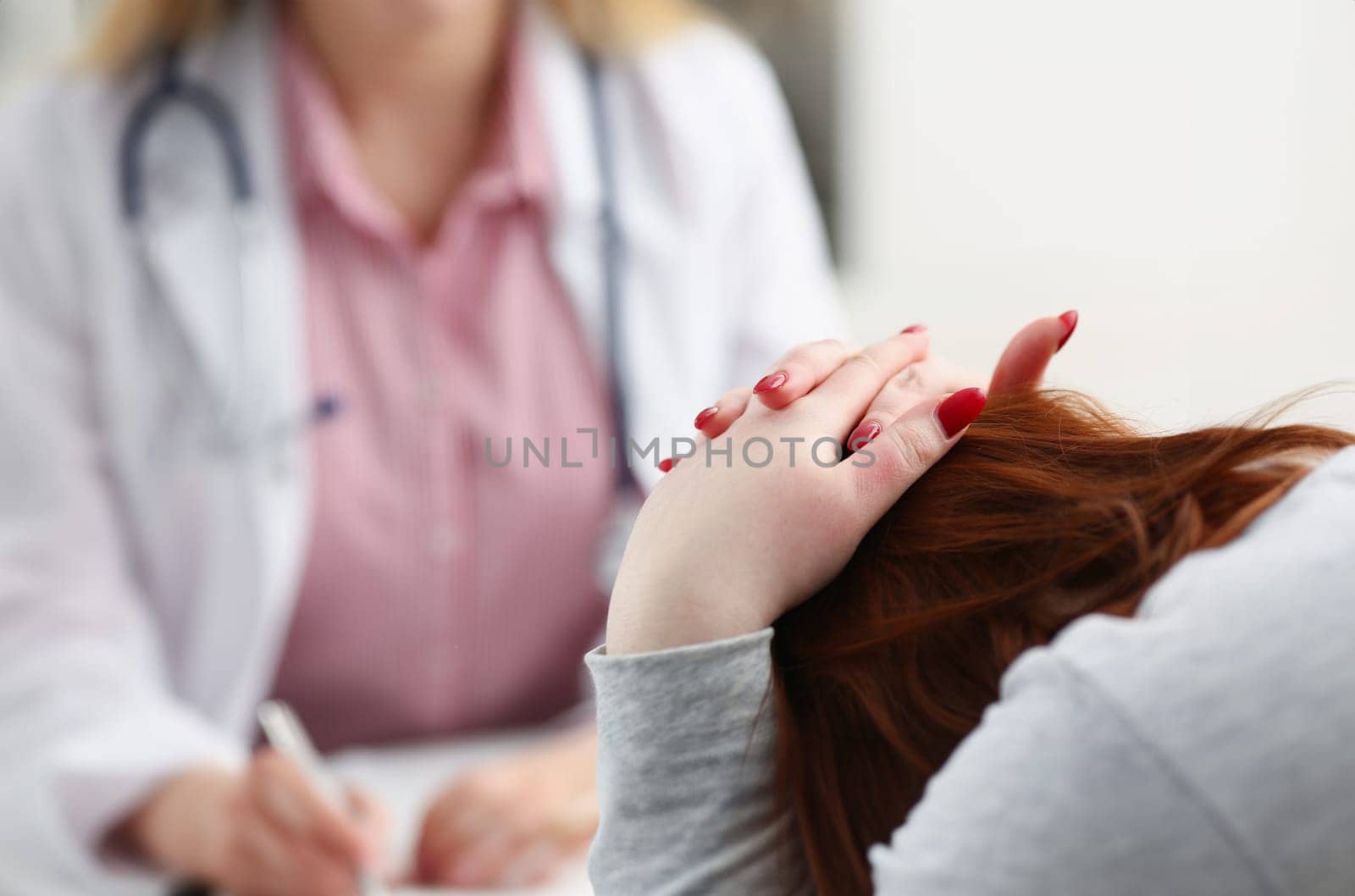 Friendly female doctor talk with thankful female patient at office and greet her with hand on shoulder gesture. Welcoming friend trust physical healthy lifestyle exam interview concept