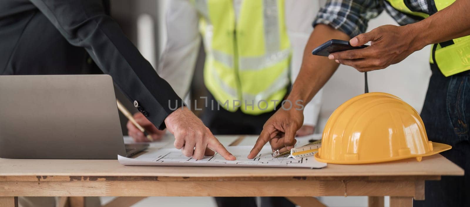 Civil engineer teams meeting working together wear worker helmets hardhat on construction site in modern city. Foreman industry project manager engineer teamwork. Asian industry professional team