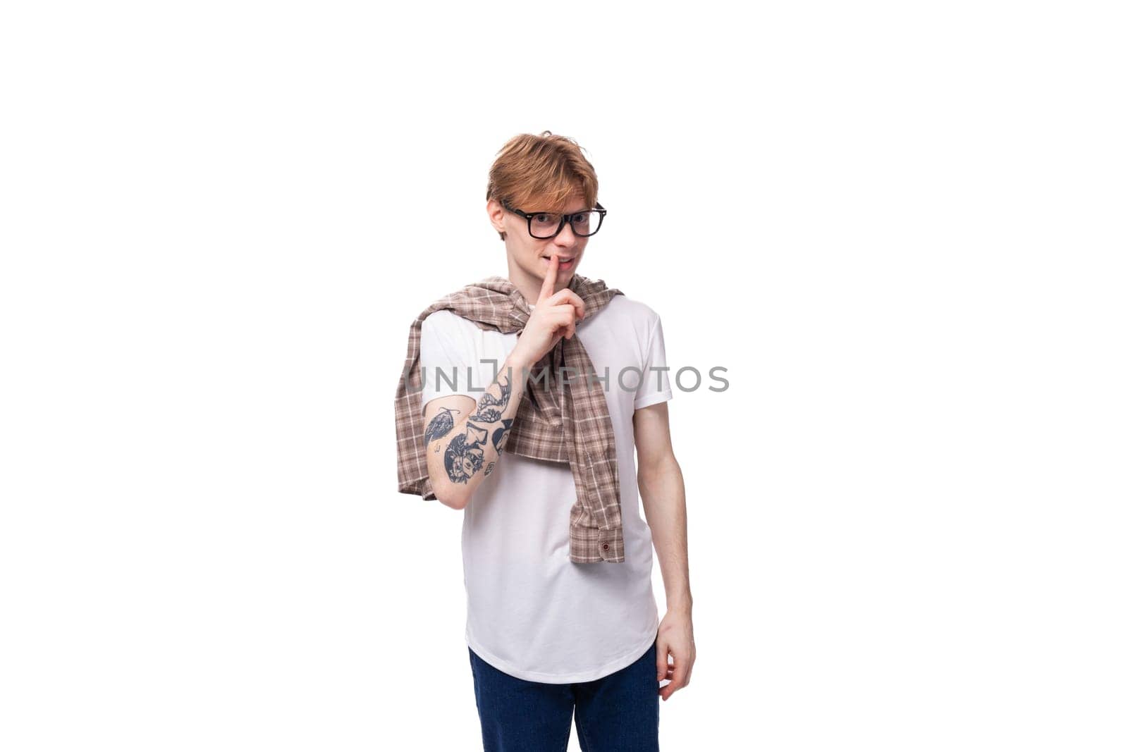 caucasian young man with red hair in a shirt actively tells the news on a white background with copy space. advertising concept.