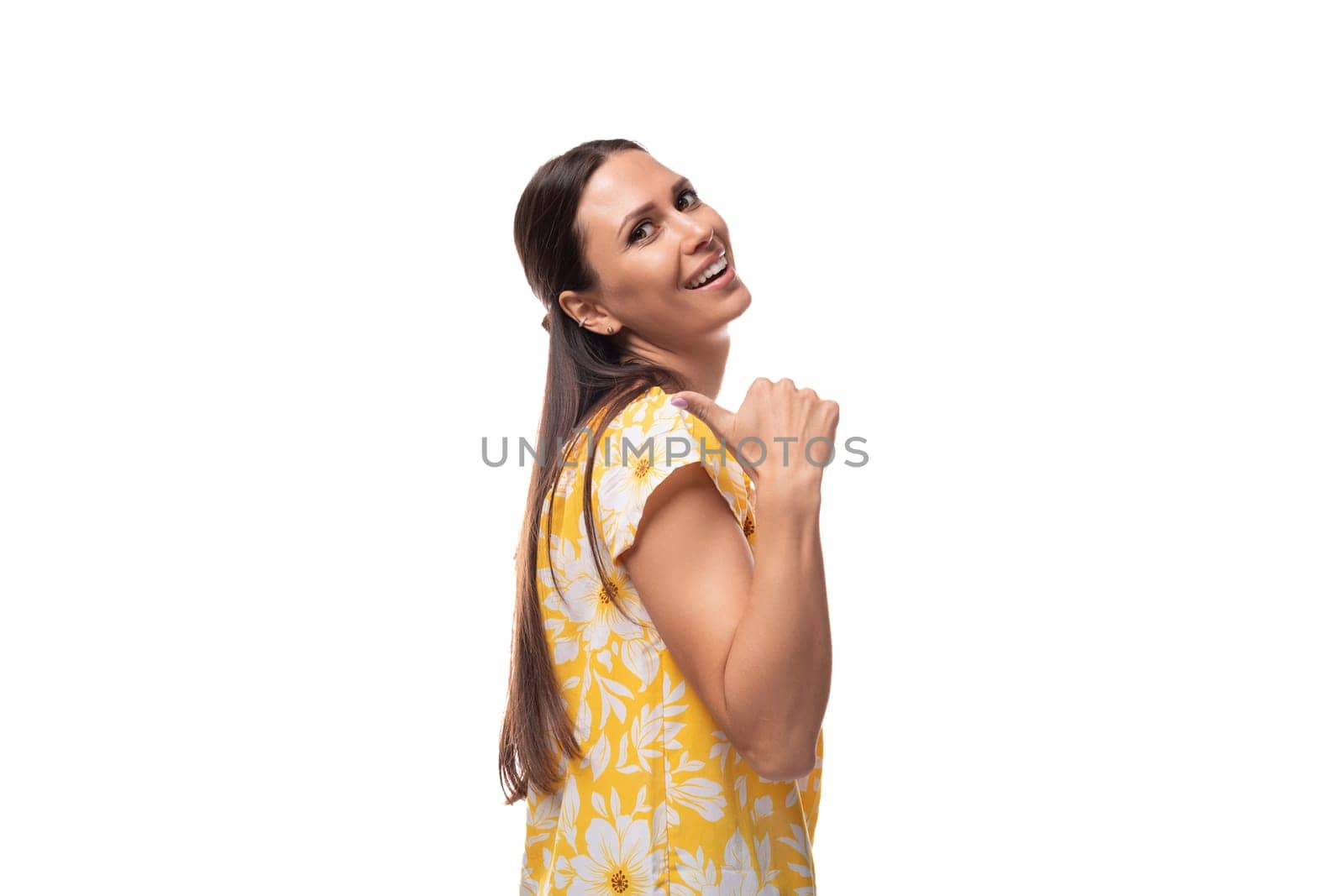 30 year old brunette woman dressed in a summer outfit smiling on a white background with copy space.