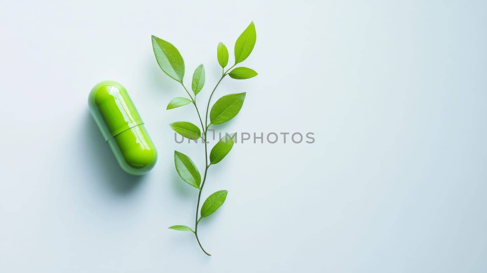 Green pill and fresh green leafy branch on light blue background. Natural medicine concept.