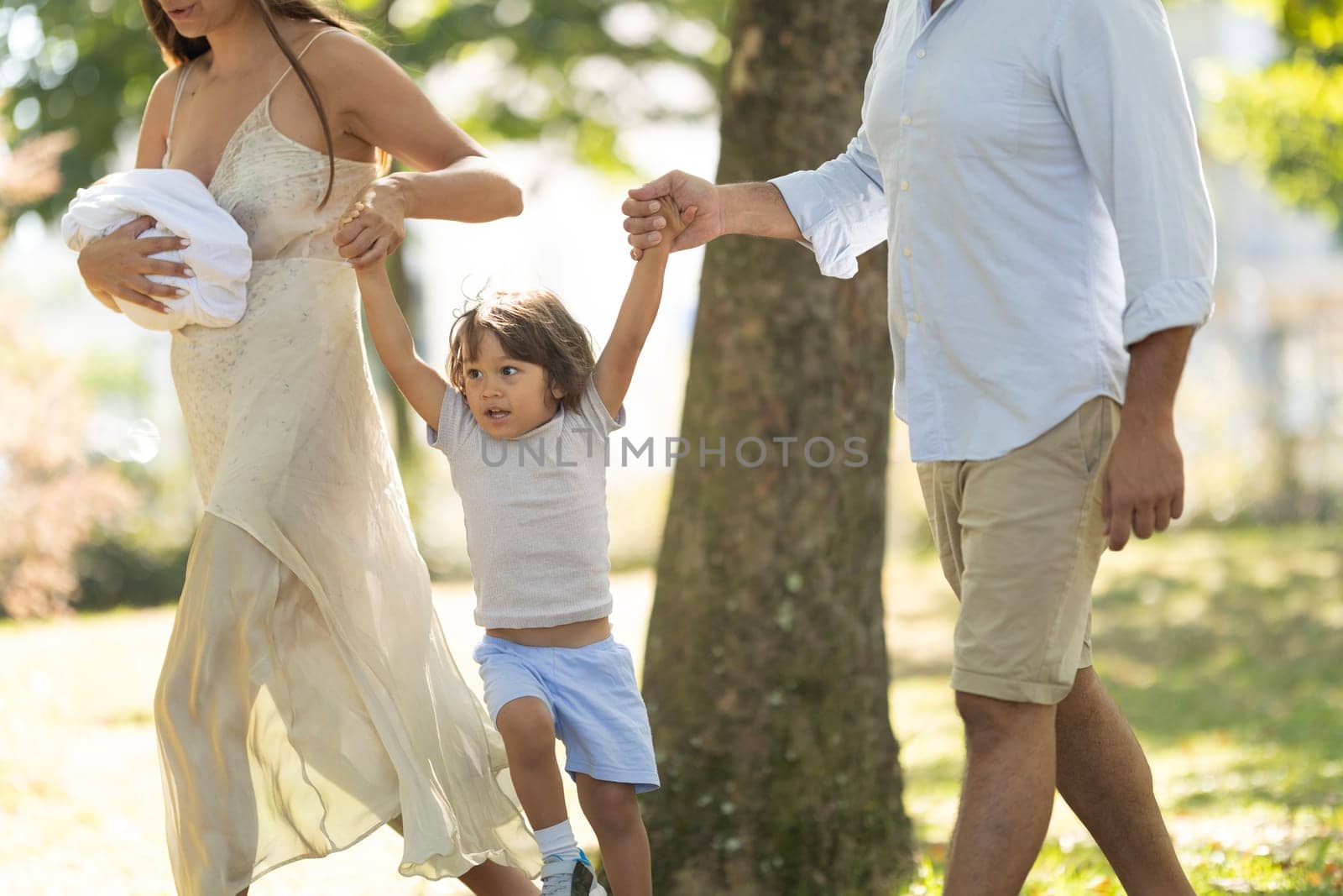 Young family is enjoying a sunny day for a walk in the park