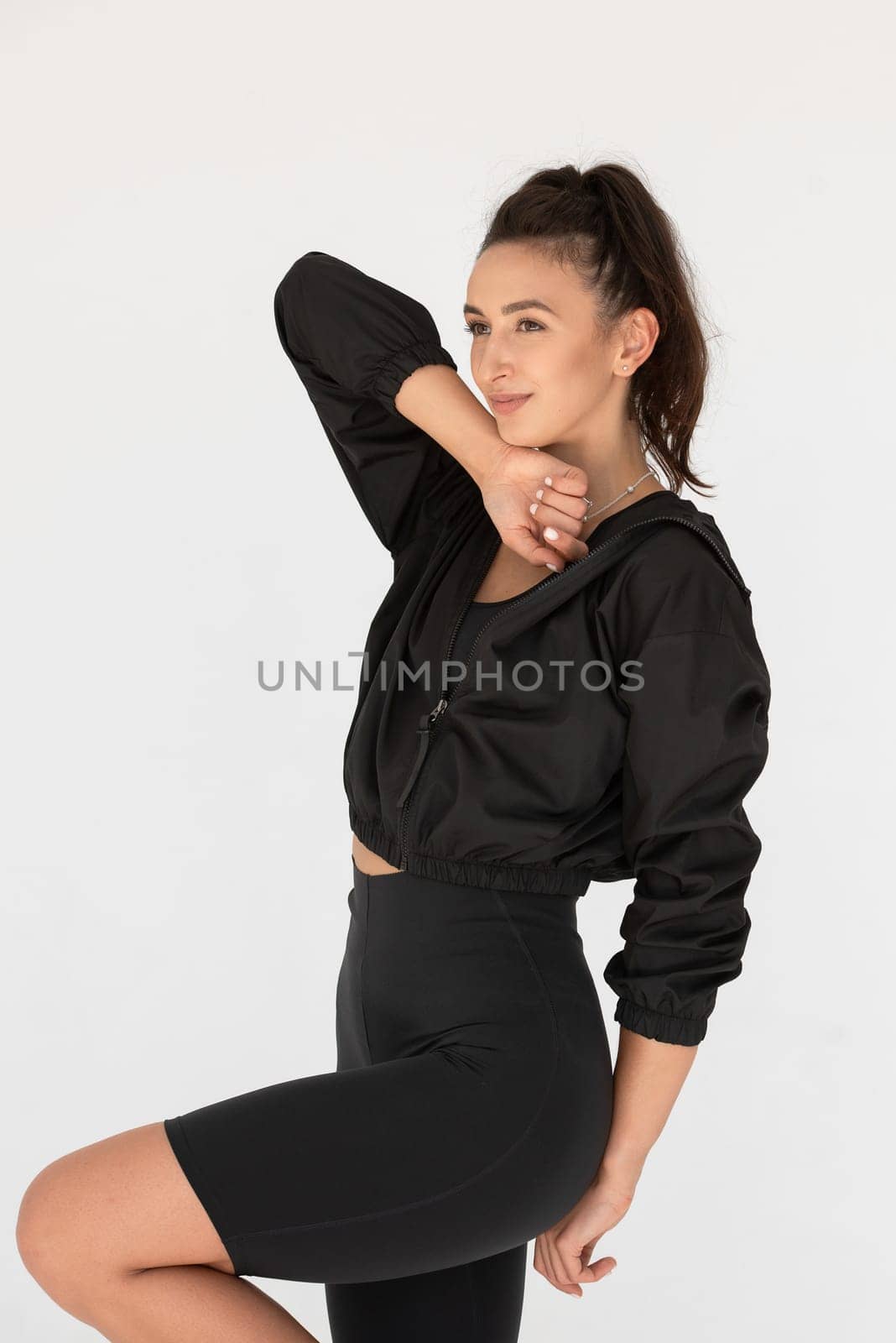 Young athlete girl posing in a black leggings and shirt. indoors.