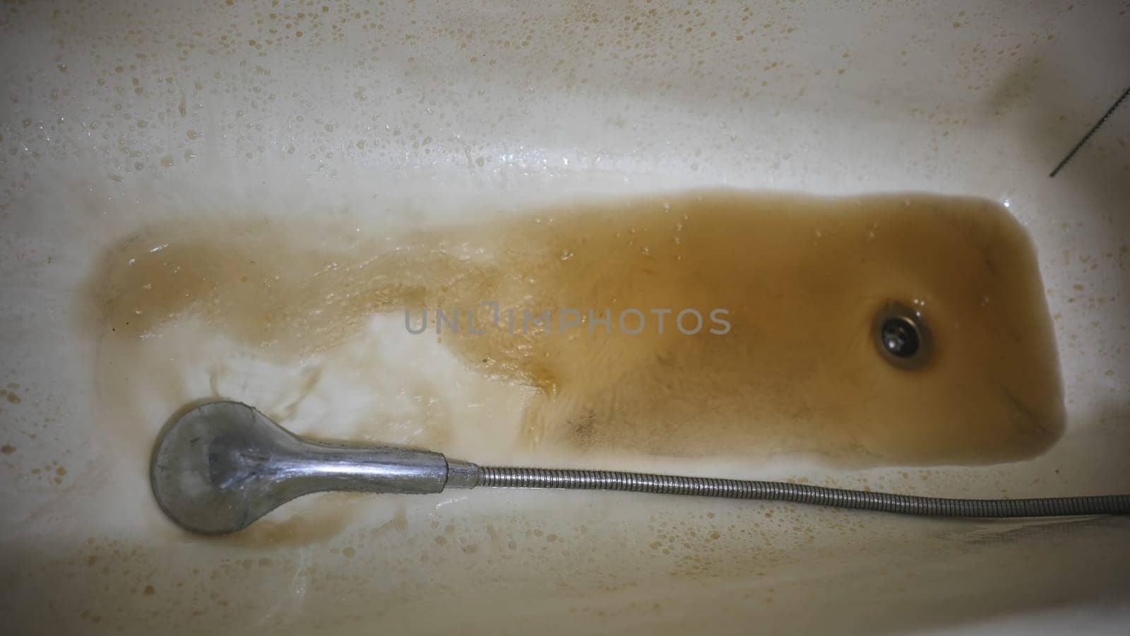 Foam from soap and rusty tap water close-up, unclean water concept, selective focus