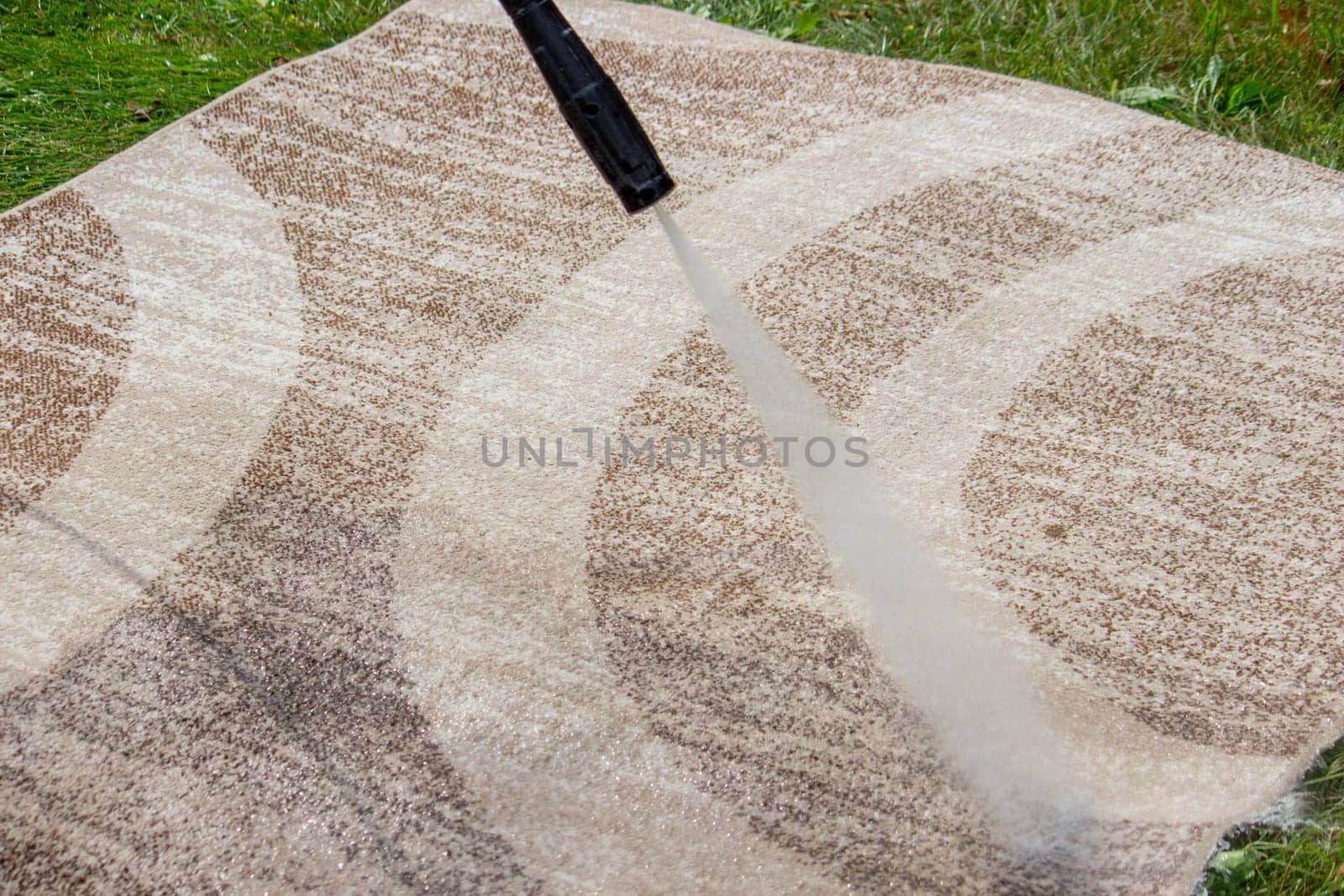 washing the carpet with a high pressure washer. Selective focus.