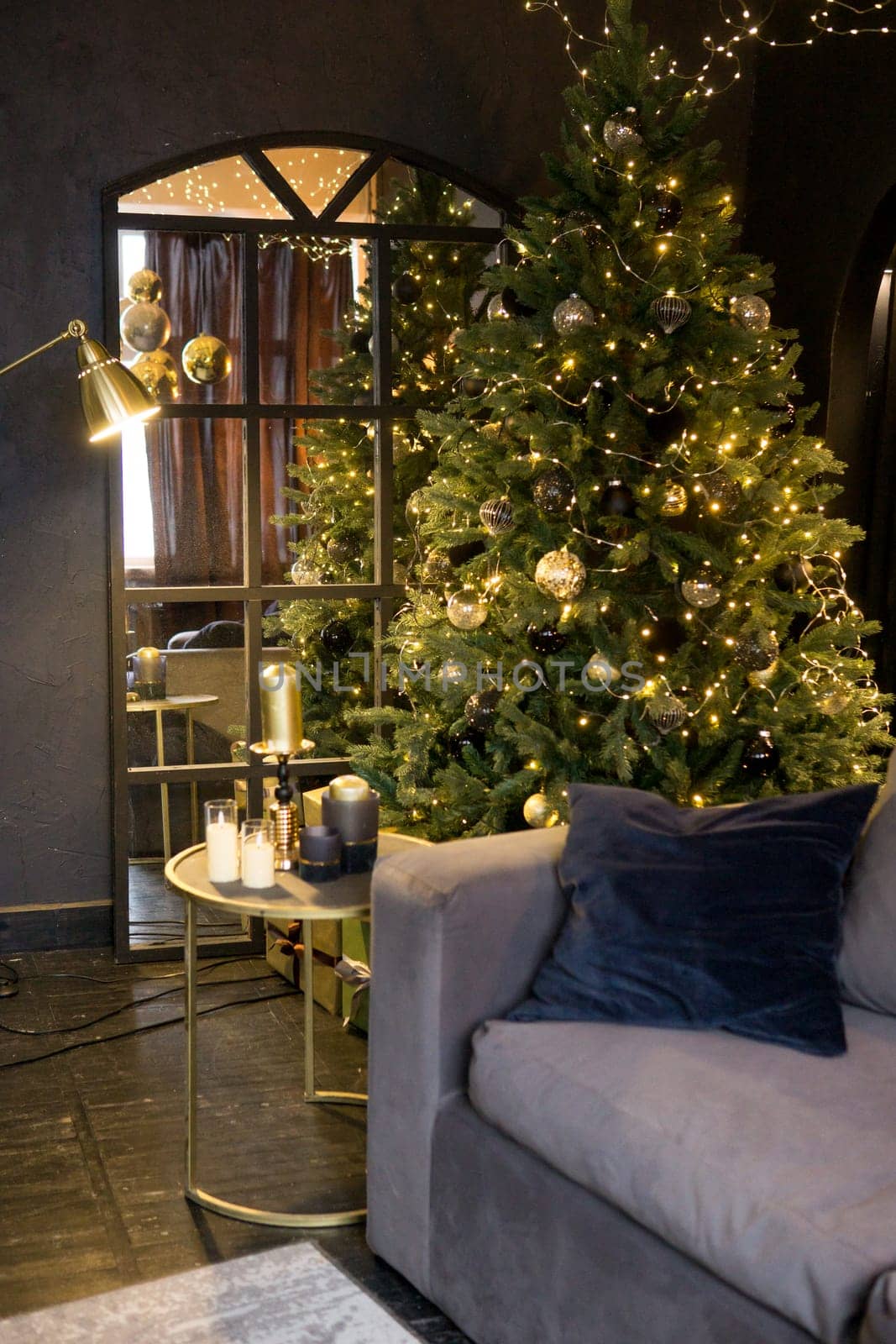 Christmas interior with a beautiful Christmas tree, sofa, light bulbs and dark background