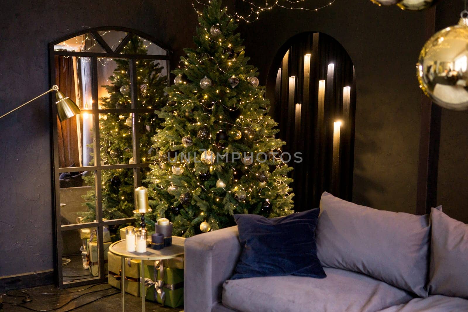 Christmas interior with a beautiful Christmas tree, sofa, light bulbs and dark background
