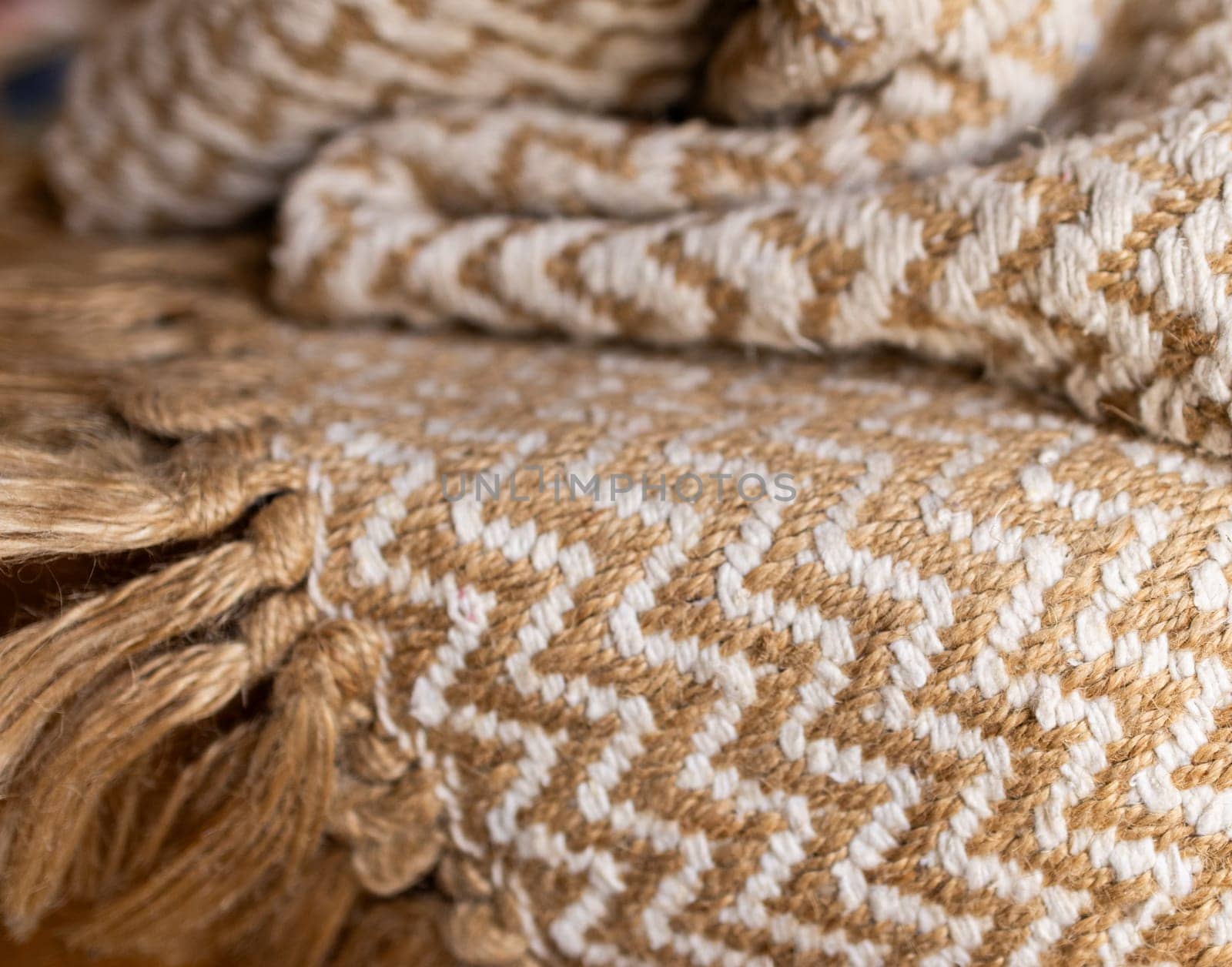 Decorative background of rustic fabric in beige tones .Wallpaper for textile products. Space for copy.High quality horizontal photo.Autumn-colored warm wool blankets.