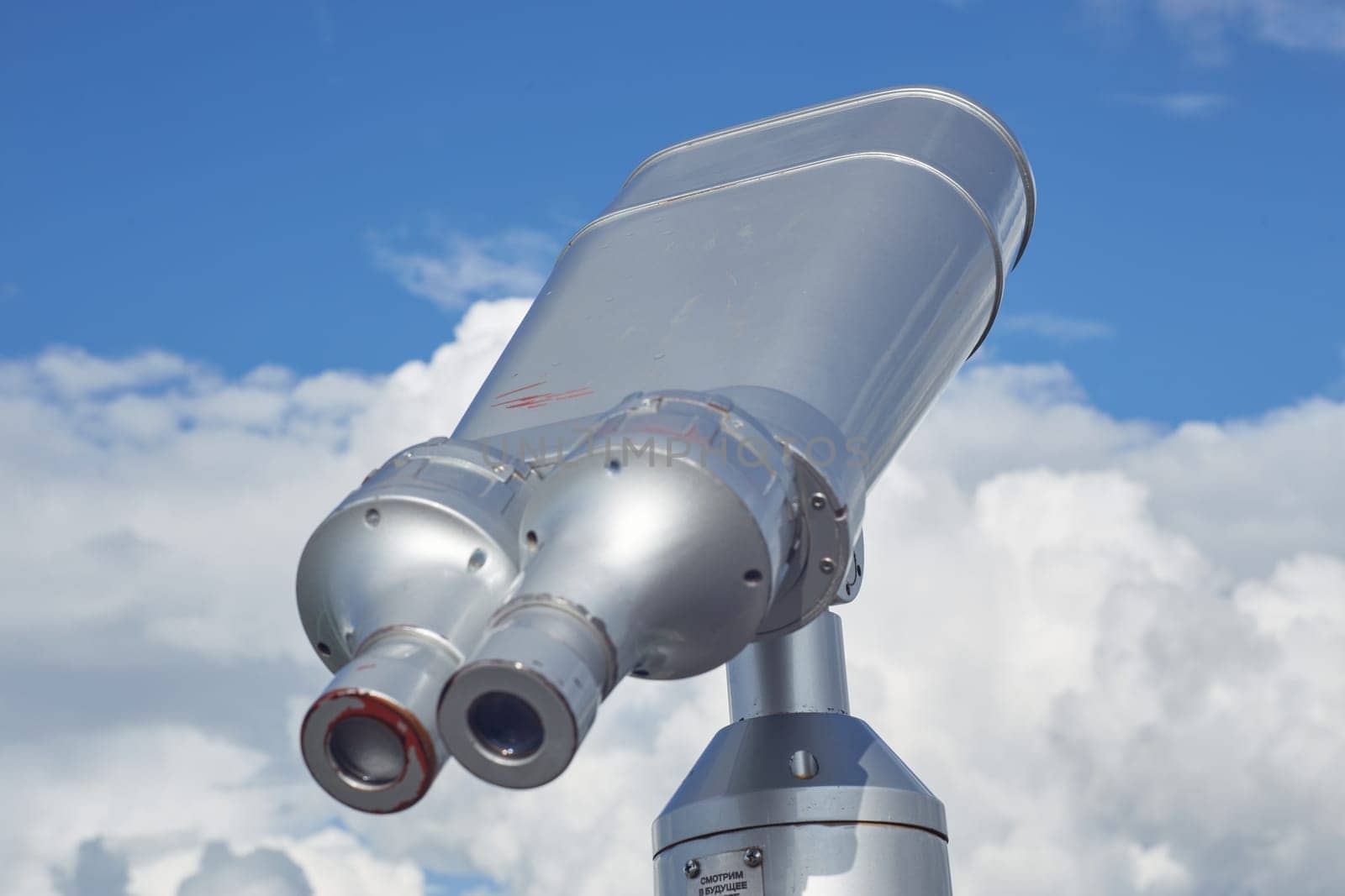 Street binoculars on a background of blue sky with clouds. Traveling , relaxing, walking around the city. Attractions.