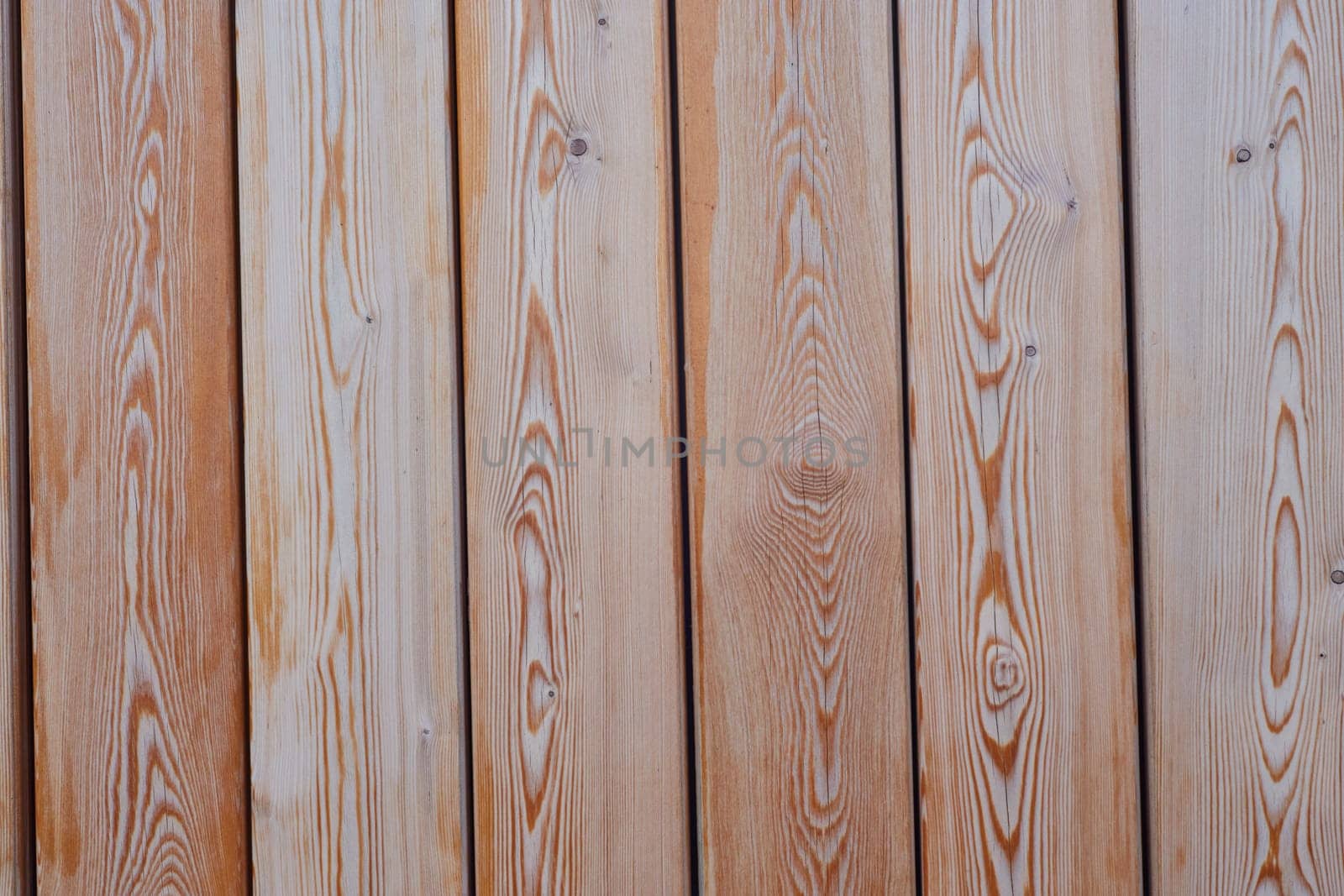WPC wood with a vertical pattern of light brown color. For construction and repair. Abstract background.