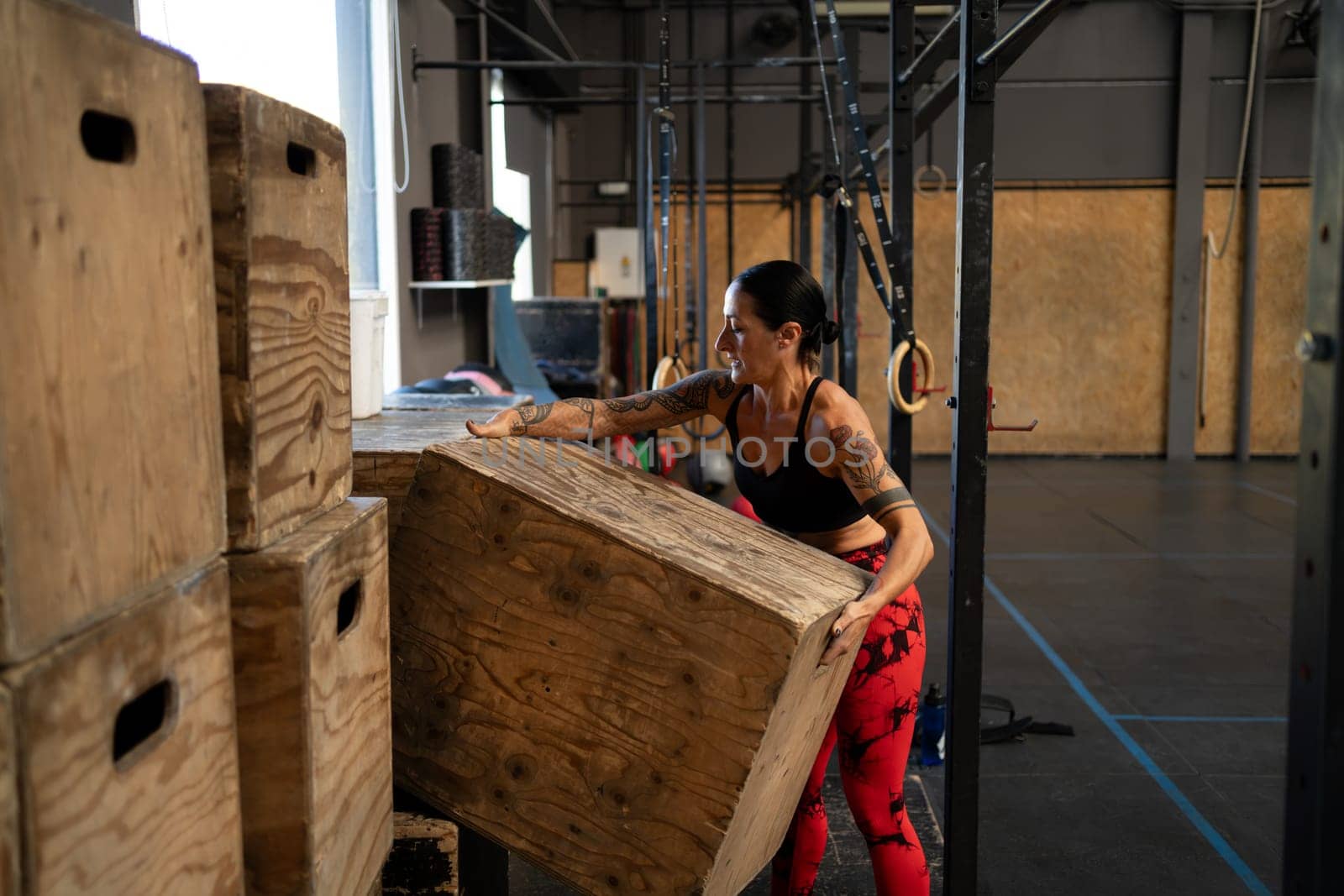 Woman organizing the gym equipment alone in a cross training gym