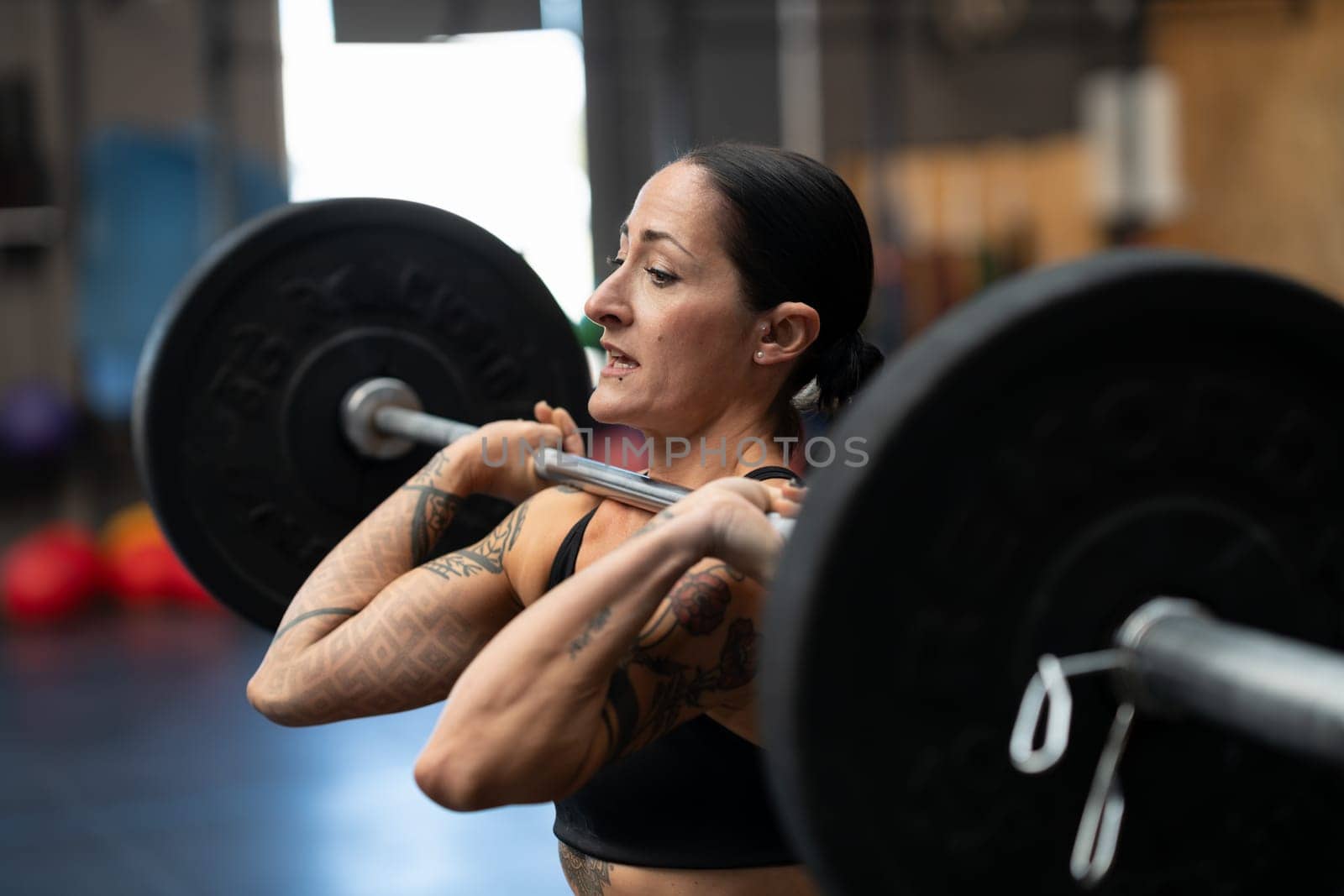 Mature female bodybuilder working out in a cross training center