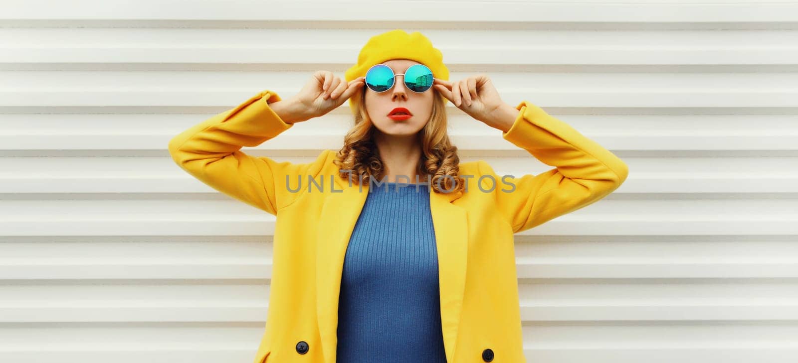 Autumn portrait of beautiful trendy young woman in yellow french beret hat, glasses, stylish girl posing on white background