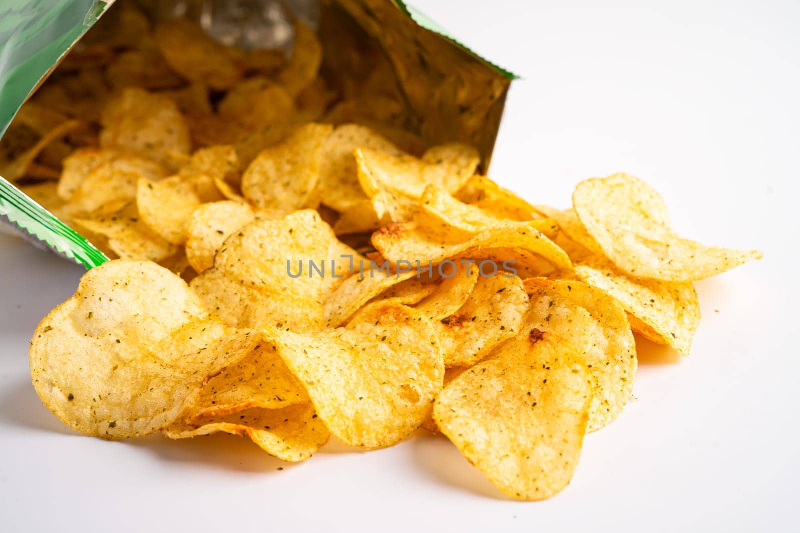 Potato chips, delicious spicy for crips, thin slice deep fried snack fast food in open bag. by pamai