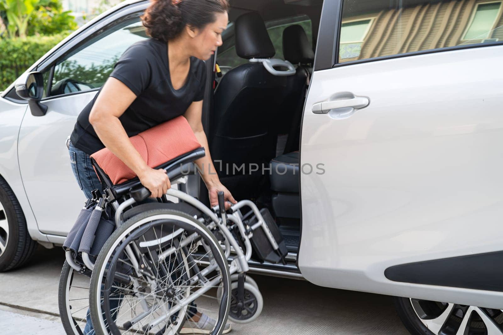 Asian disability woman on wheelchair getting in her car, Accessibility concept. by pamai