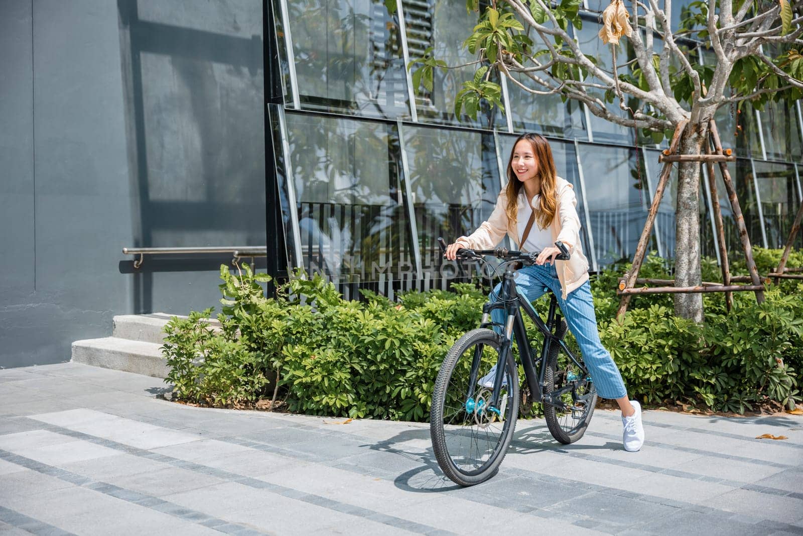 Happy Asian beautiful young woman riding bicycle on street outdoor near building city, Portrait of smiling female lifestyle using bike in summer travel means of transportation, ECO friendly