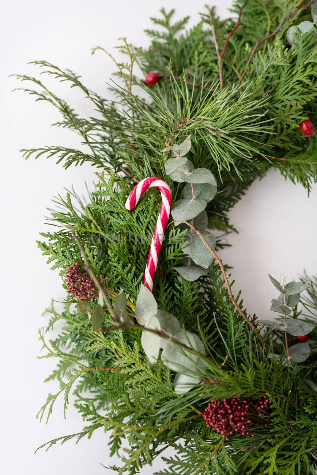 Stylish Christmas wreath for the interior, hang the wreath on the door. Handmade wreath with red festive candy. Festive atmosphere