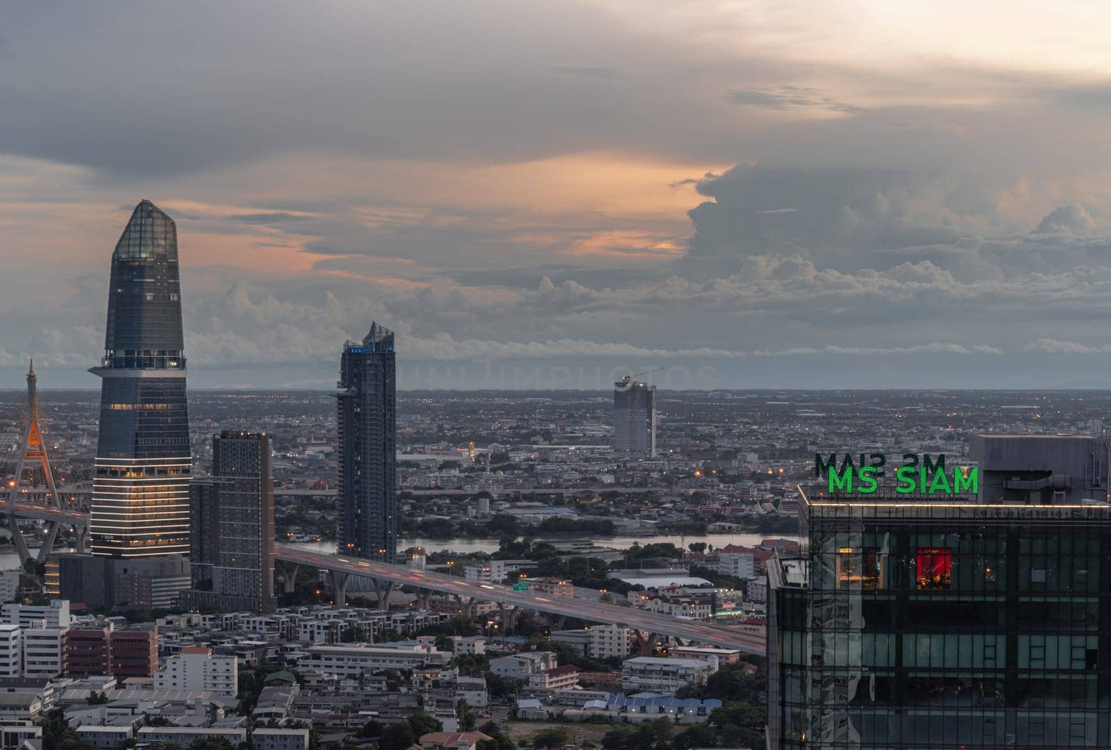 Bangkok, Thailand - Aug 22, 2024 - City view with KingBridge tower alongside the iconic landmark of Bhumibol Bridge and MS Siam Tower at Evening. Stunning skyline of bangkok business district with Skyscrapers at before sunset use it as your wallpaper, poster and banner design, Selective focus.
