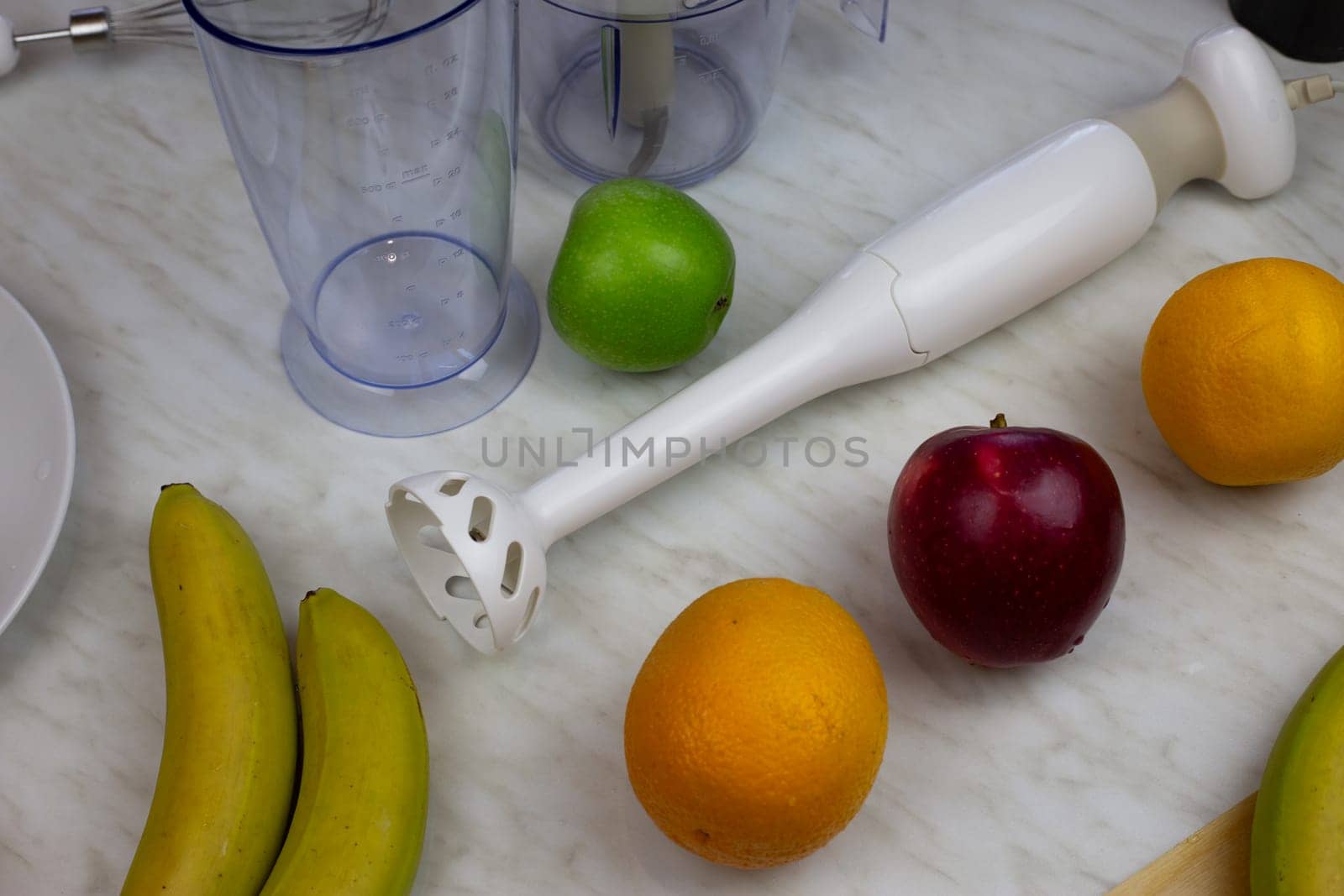 Blender lies on the table next to fruits. Ingredients for grinding in a blender. Fresh fruits for creating a sports drink for people health