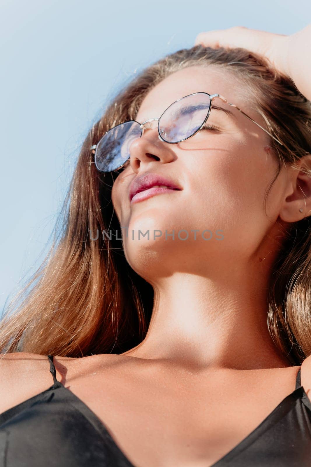 Woman travel sea. Young Happy woman in a long red dress posing on a beach near the sea on background of volcanic rocks, like in Iceland, sharing travel adventure journey