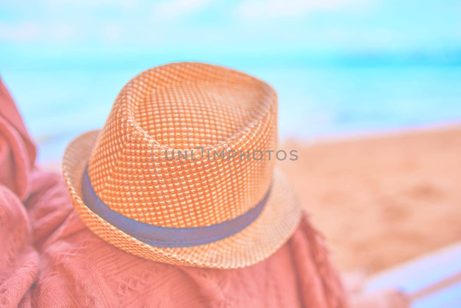 Straw hat on a hot day off on womans leg with plaid