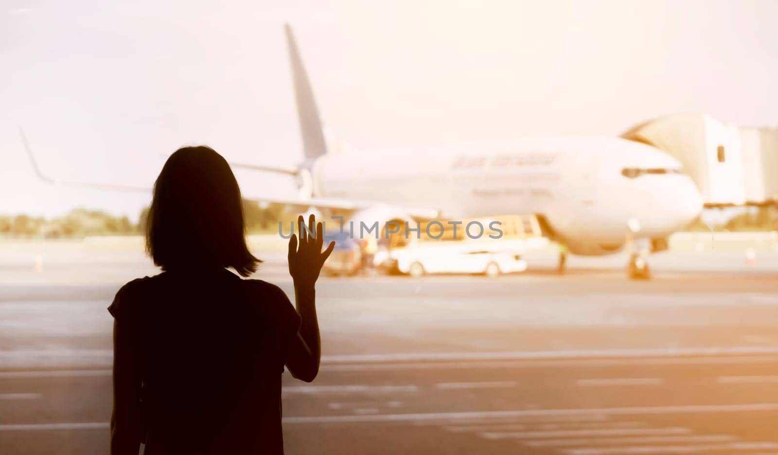 A young girl at the airport is boarding a plane at sunset, a woman goes on a journey.